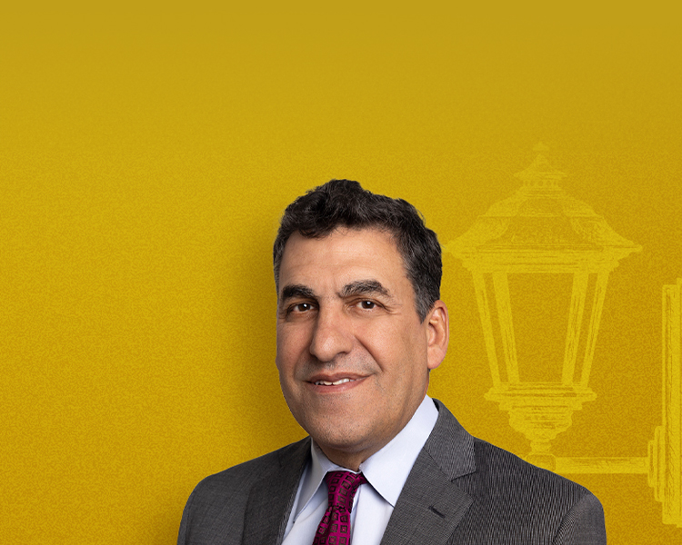 Photograph of Bernard D’Orazio with a vibrant yellow background, with a white silhouette and a black silhouette of a lamppost also in the background