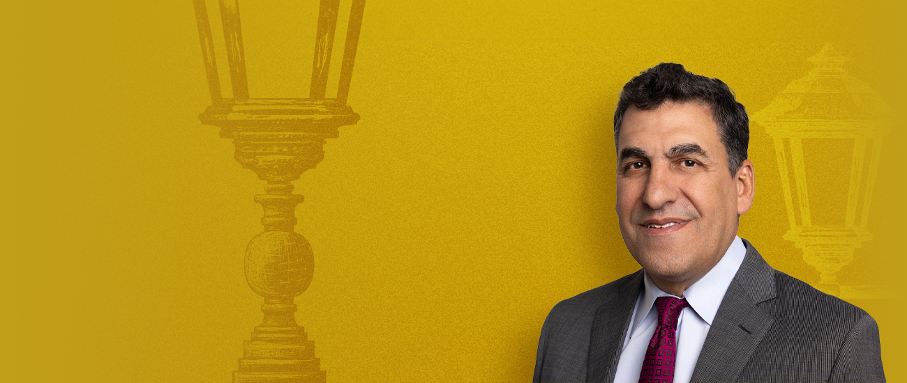 Photograph of Bernard D’Orazio with a vibrant yellow background, with a white silhouette and a black silhouette of a lamppost also in the background